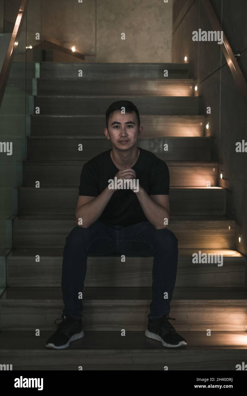 Asian young handsome man sitting on the stairs shop and smiling ...