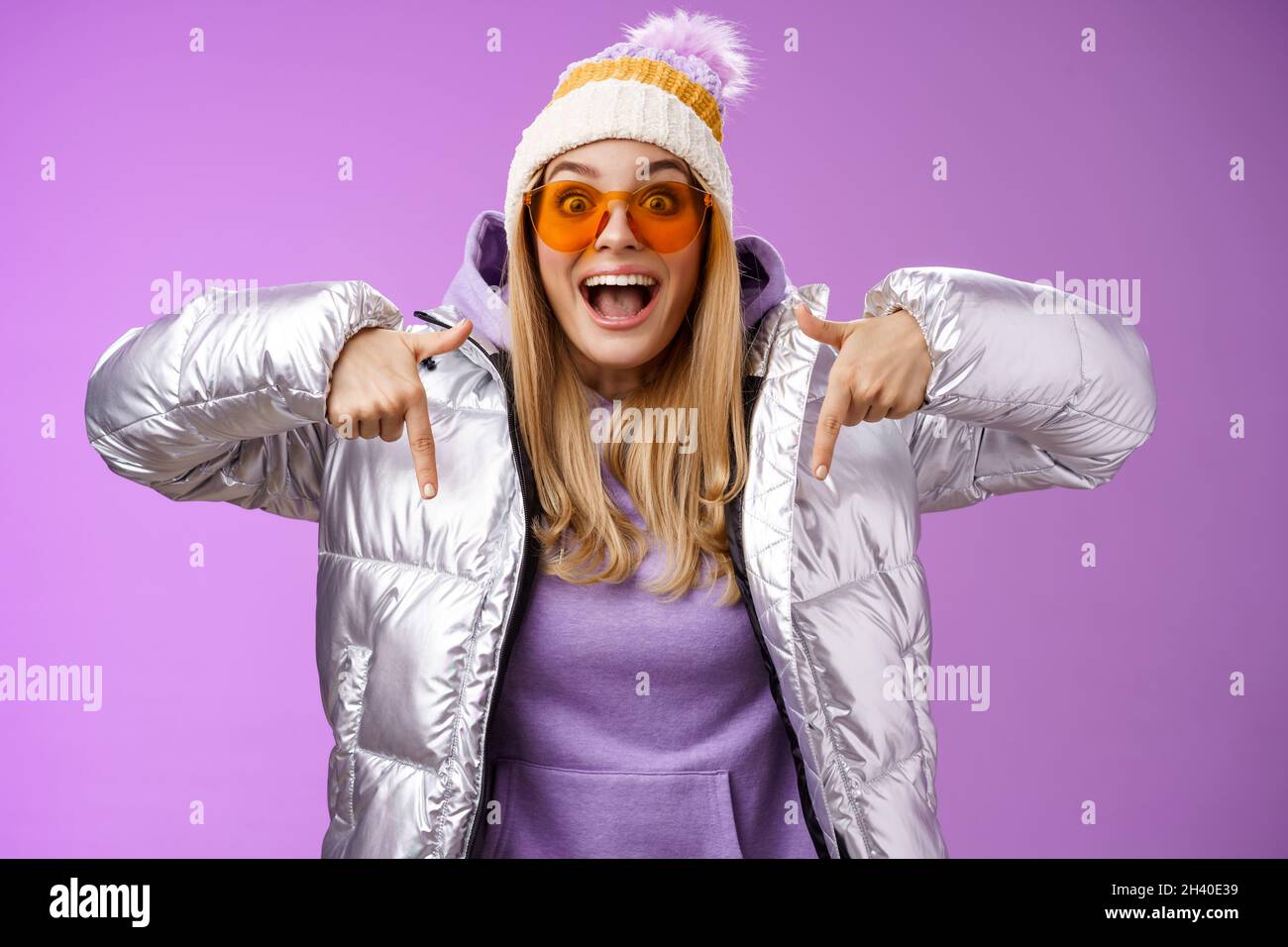 Excited impressed good-looking blond girl drop jaw amused overwhelmed pointing down index fingers checking out awesome promotion Stock Photo
