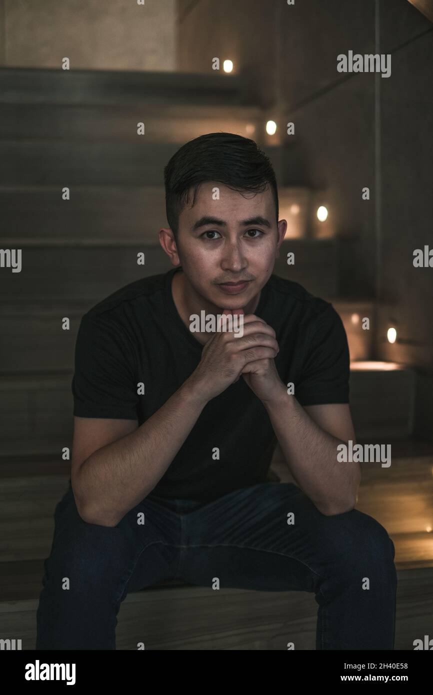 Asian young handsome man sitting on the stairs shop. Chinese guy ...