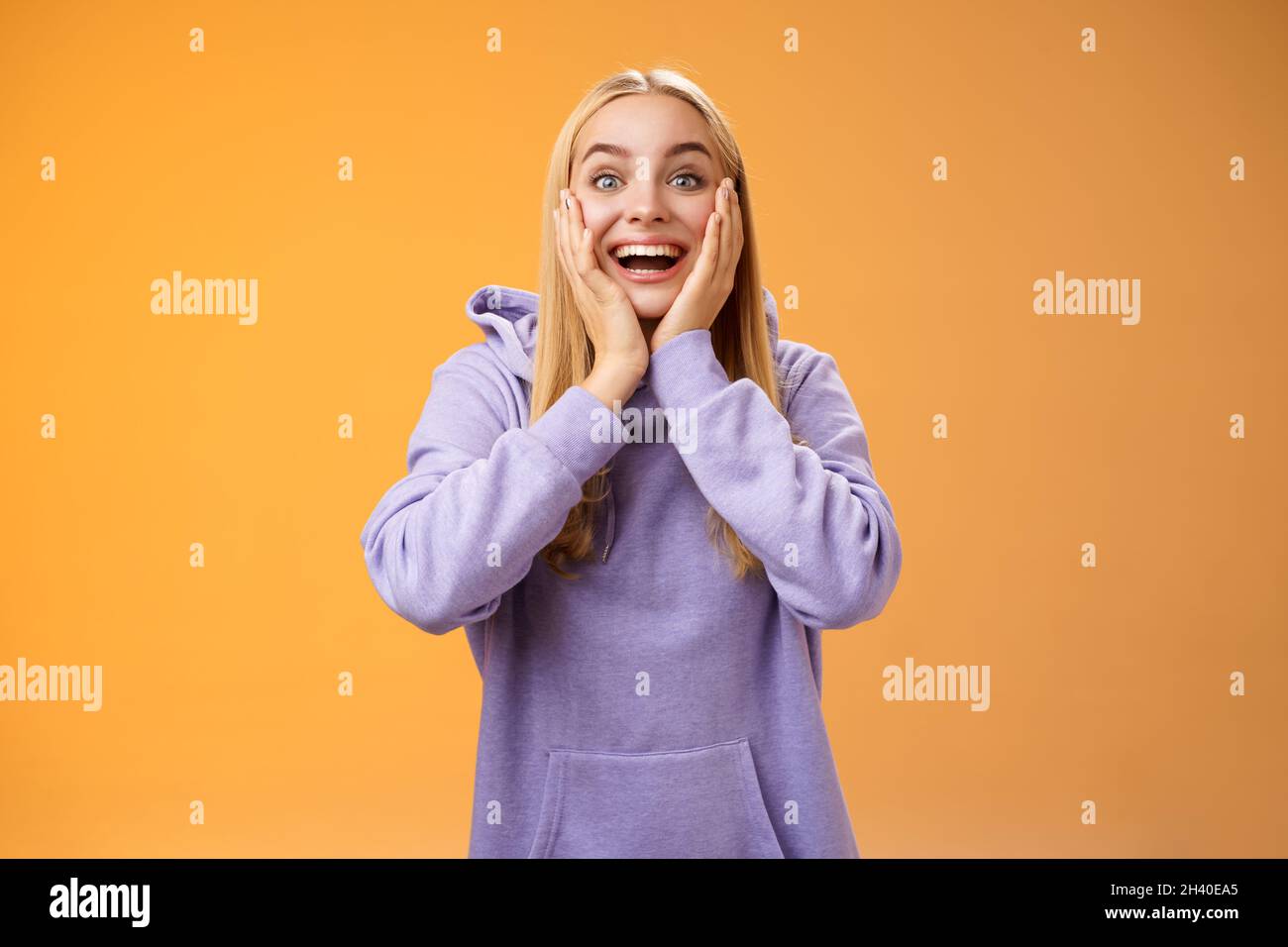 Surprised happy astonished fair-haired girlfriend receive incredible super cute gift touch cheeks amused reacting satisfied impr Stock Photo