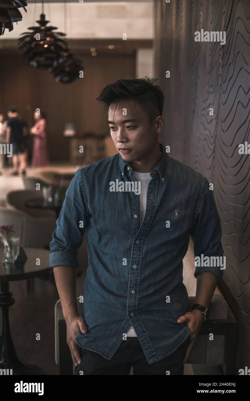 Asian young handsome man standing in coffee shop and smiling. Chinese guy, millennials life, lifestyle in the big city, Modern Asia, coffee break Stock Photo