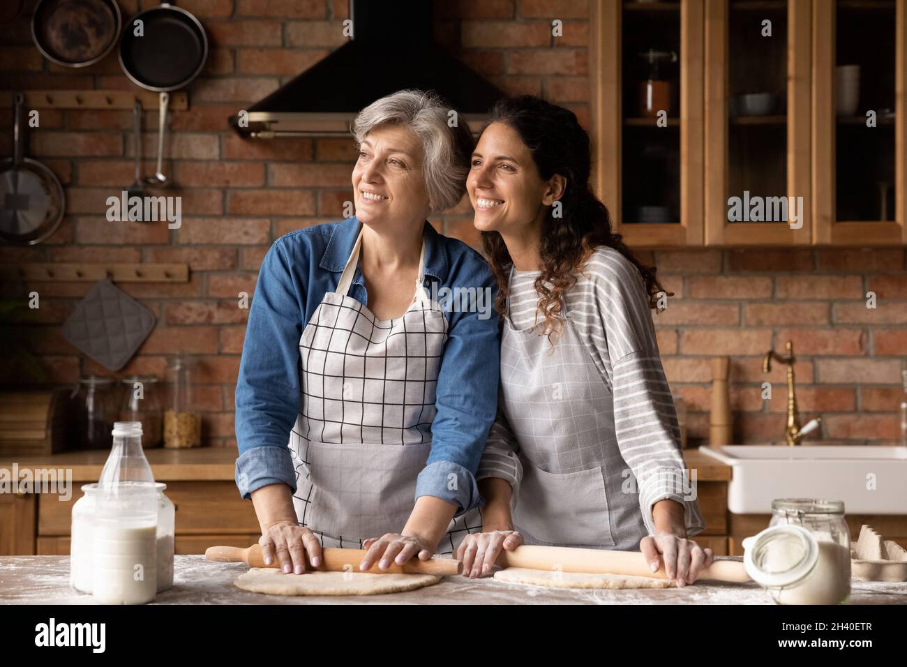 Happy mature 60s mother and grown daughter woman baking pie Stock Photo