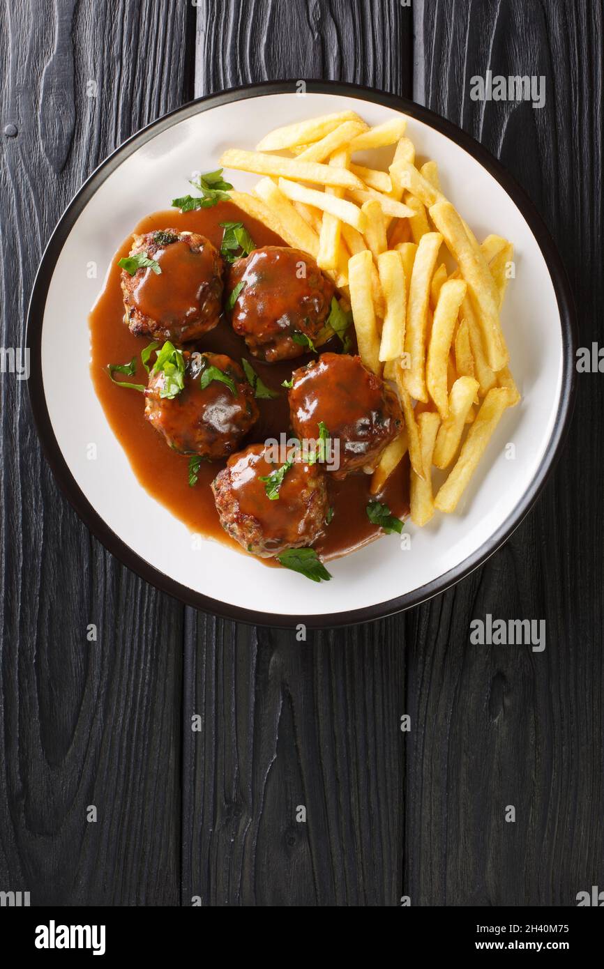 Boulets liegeois is a popular dish served all over Belgium made of meatballs swimming in an apple and onion gravy served with fries closeup in the pla Stock Photo