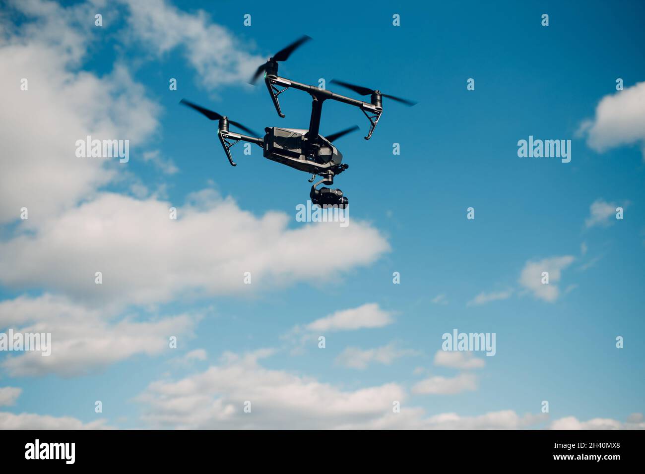 Big quadcopter drone against blue sky aerial flight and filming. Stock Photo