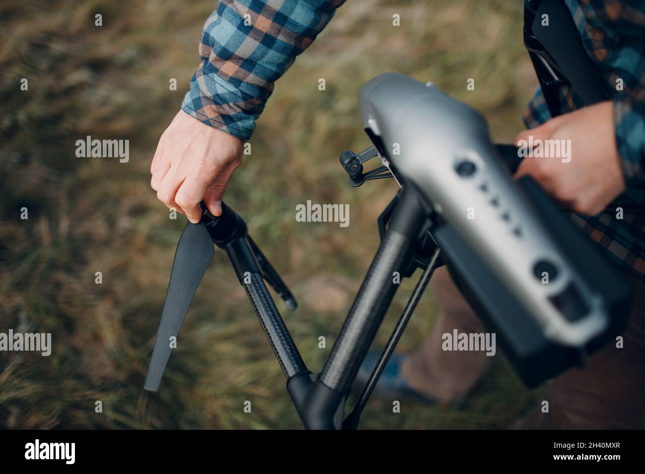 Man pilot checking quadcopter drone before aerial flight and filming. Stock Photo