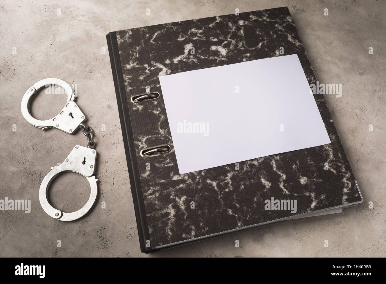 Folder with documents and handcuffs on the table, punishment concept, template for designers Stock Photo