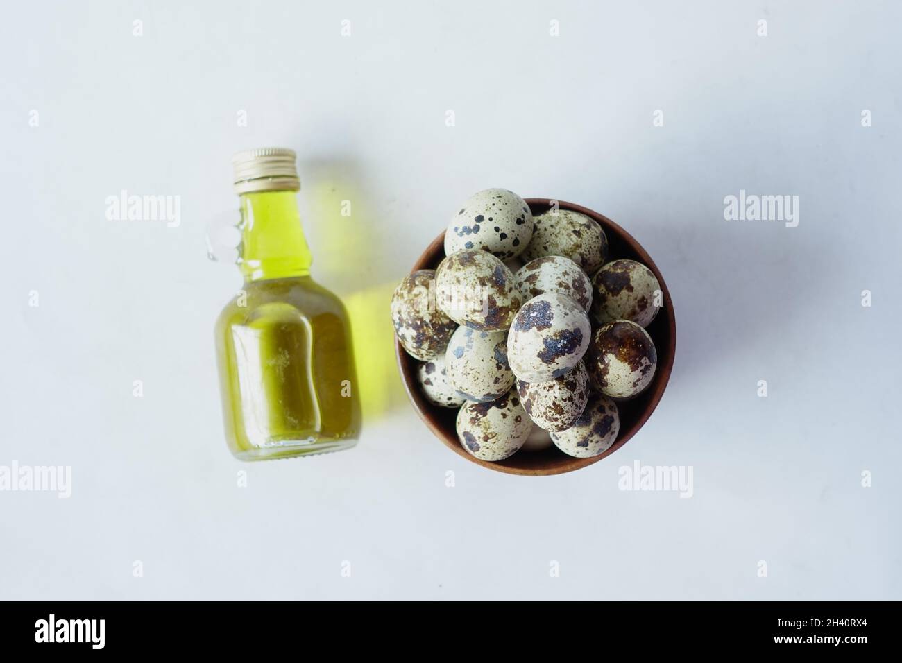 top view of Quails eggs in a bowl with oil on white background  Stock Photo