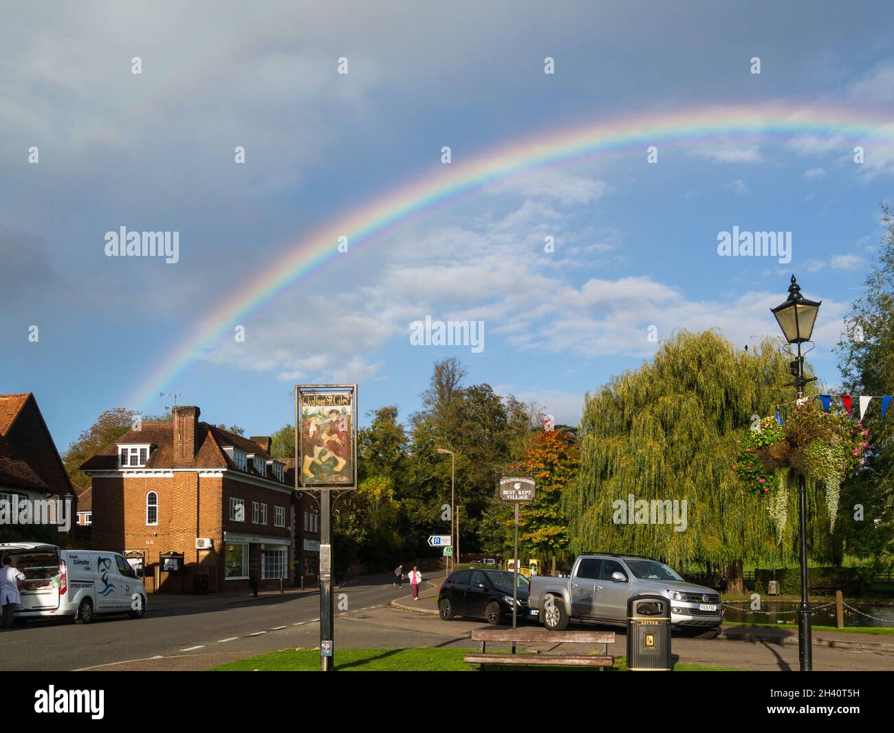 Main street duckpond and village sign with rainbow Chalfont St Giles Buckinghamshire England UK Stock Photo