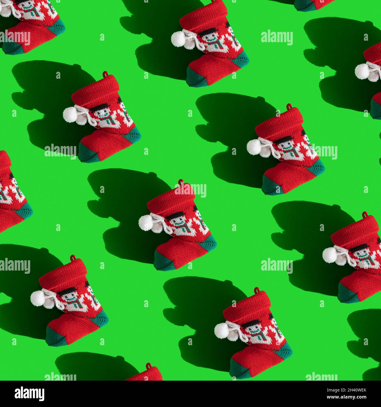 Seamless Festive background with red Santa’s boots on green, top view
