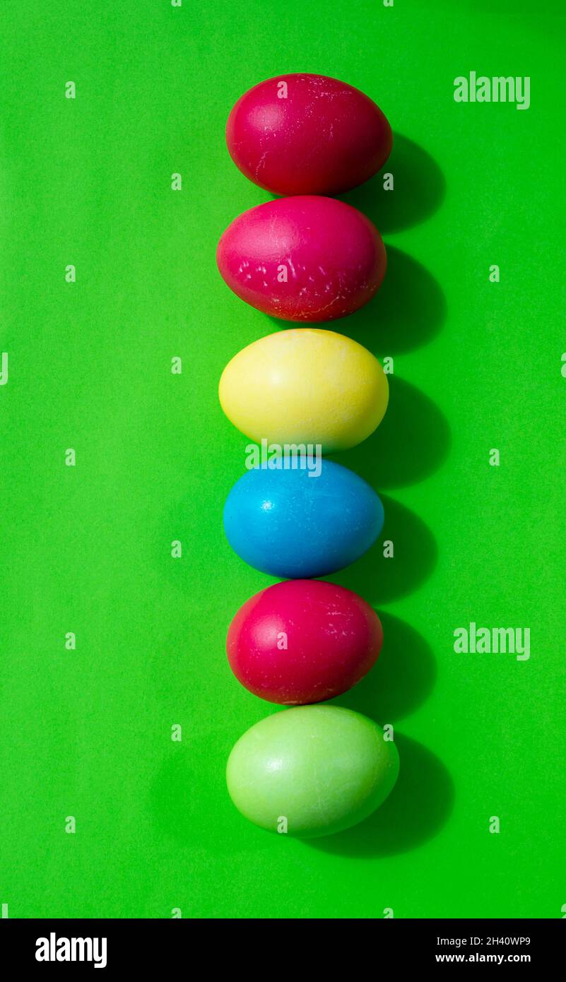 Easter backgrounds. Multicolored Easter eggs on a bright green background. Vertical. Stock Photo