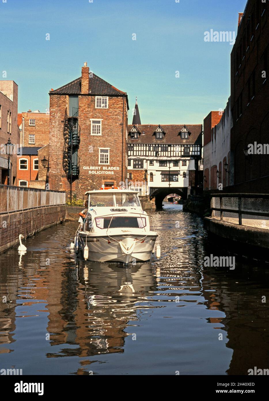 Boat and swan on the River Witham with the High Street Bridge to rear, Lincoln, UK. Stock Photo