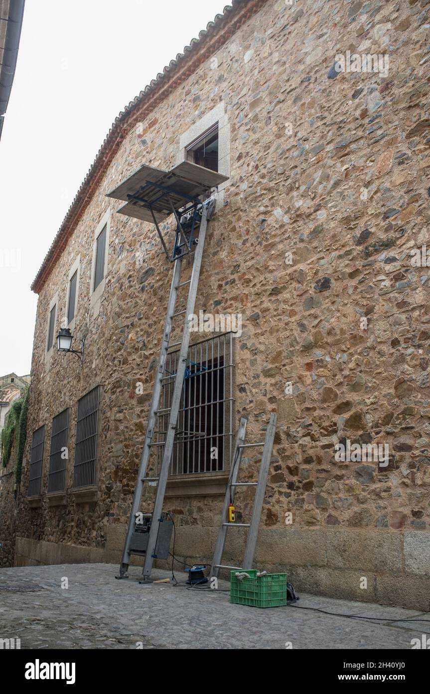 Aluminum ladder lift at work. Historic walled area moves concept Stock Photo