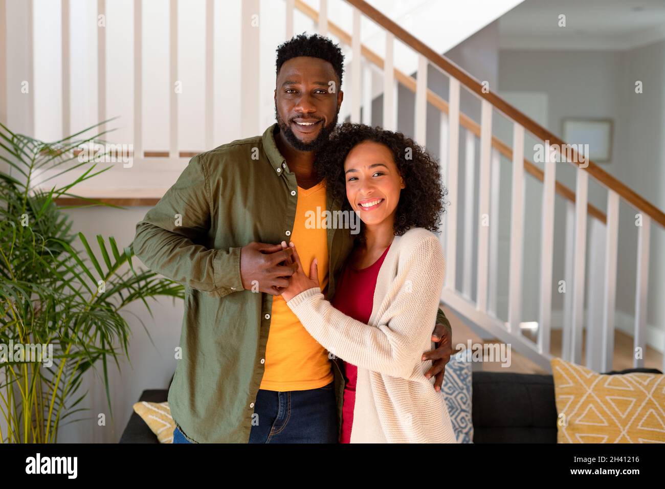 Happy african american couple hugging and looking at camera Stock Photo ...
