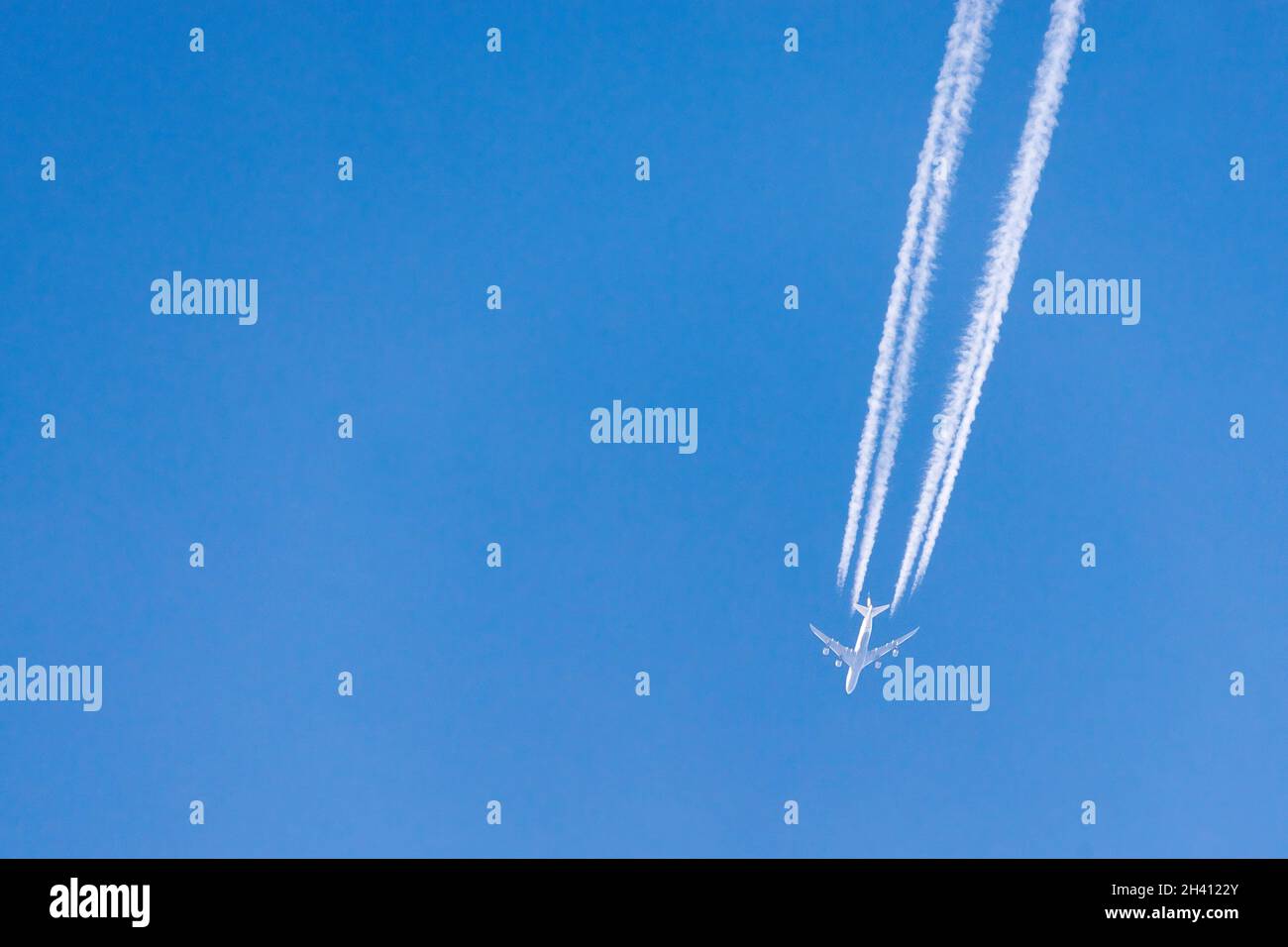 Contrails formed from engine exhaust of aeroplane against clear blue