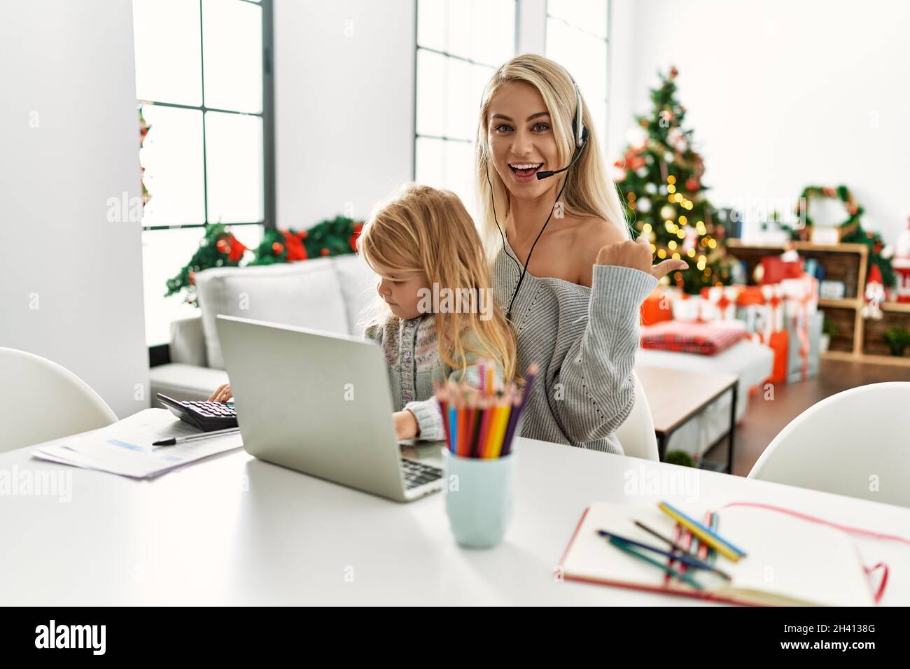 Mother of caucasian daughter wearing call center agent headset at home ...