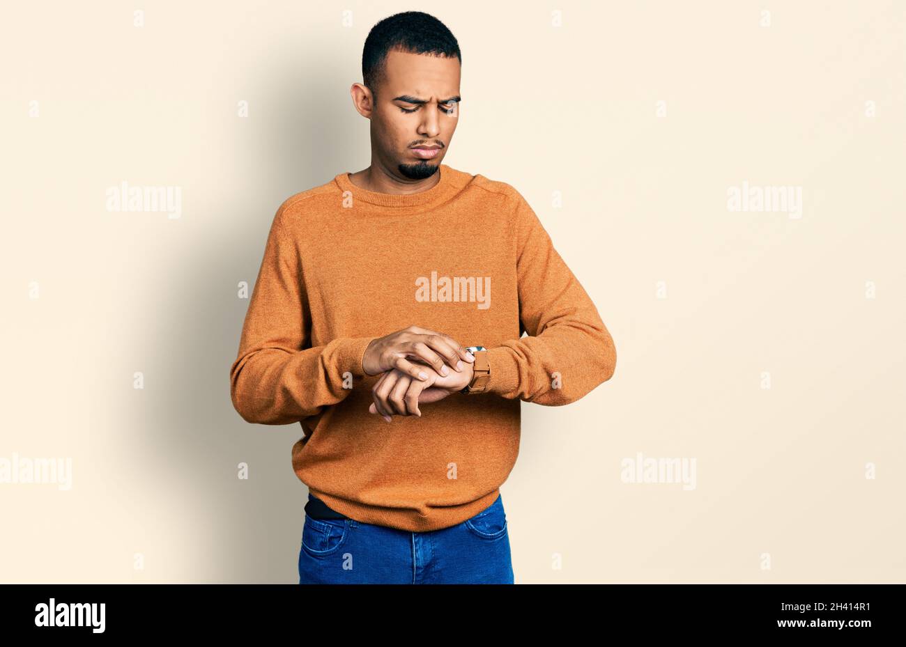 Young african american man wearing casual clothes checking the time on ...