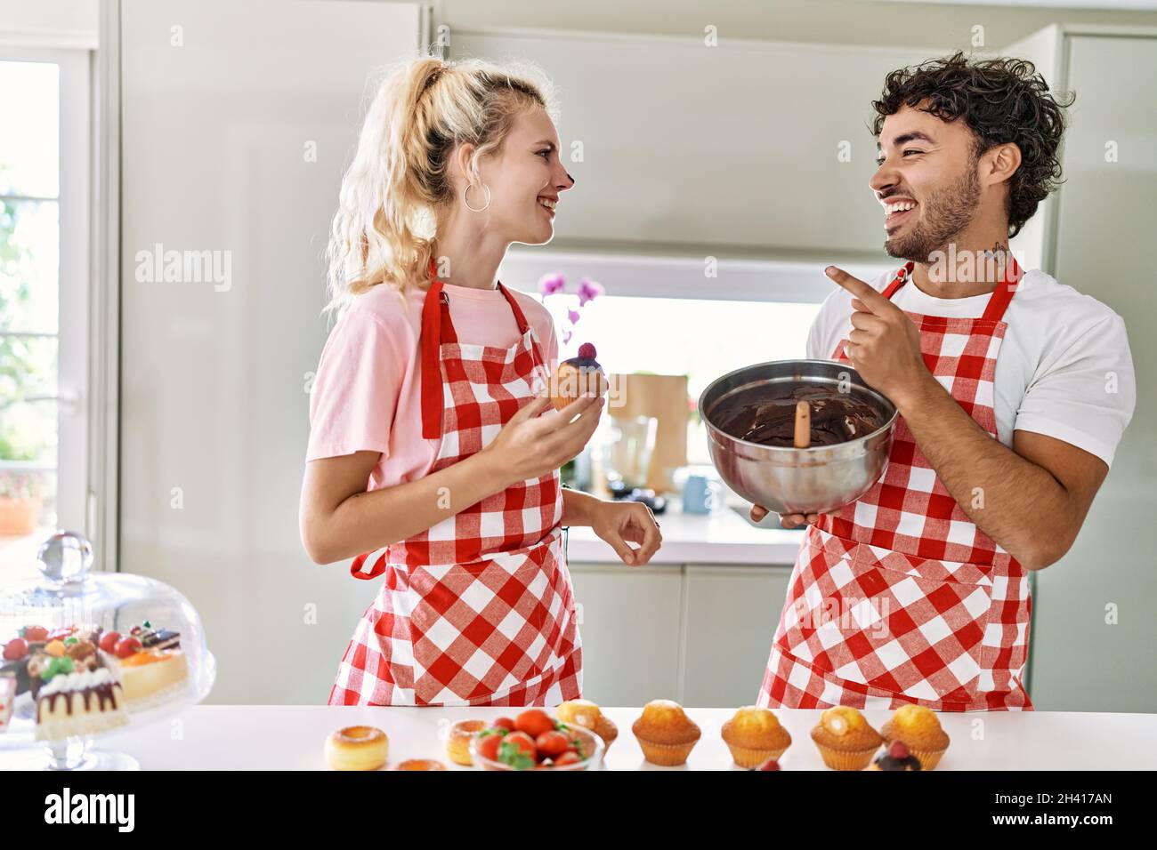 Young couple smiling happy cooking sweets at kitchen Stock Photo - Alamy