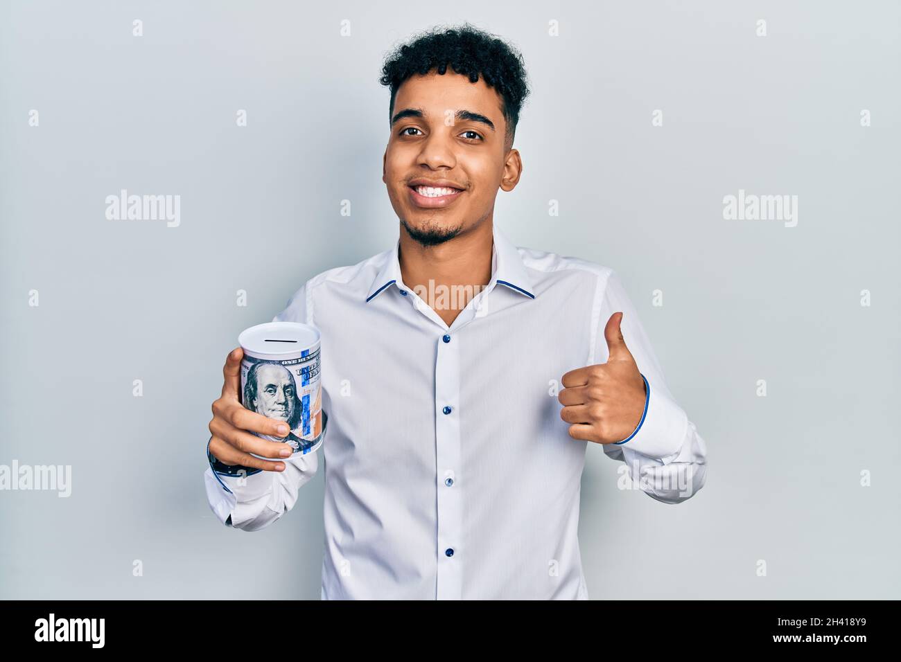 Young african american man holding piggy bank smiling happy and ...