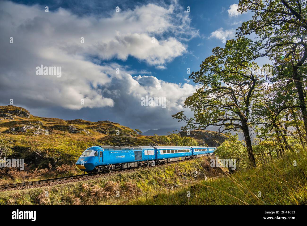 The image is of the HS2 diesel powered Pullman train passing through Glen Finnan on the Fort William to Mallaig line during a private hire excursion Stock Photo