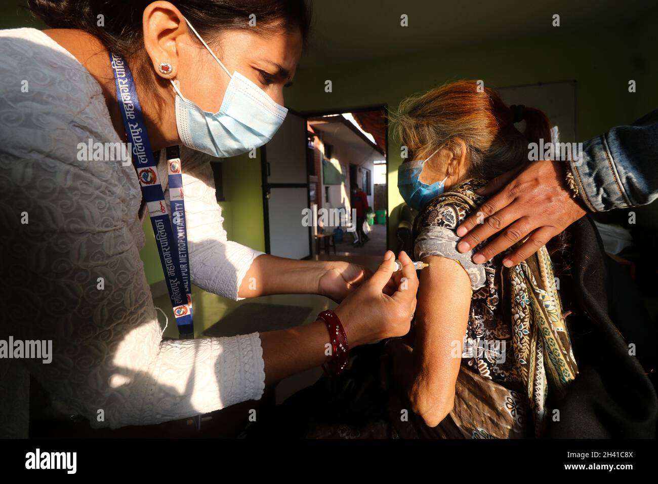 Kathmandu, NE, Nepal. 31st Oct, 2021. A Nepali paramedic inoculates a septuagenarian with anti-pneumonia vaccine (PCV-13) at a local vaccination center in Lalitpur District of Nepal on 31 October, 2021. The Lalitpur Metropolitan in first phase of the campaign has started inoculation drive that targets people above 74 years to be jabbed against pneumonia in wake of rising COVID-19 cases and dropping mercury in recent days in the Himalayan Nation. (Credit Image: © Aryan Dhimal/ZUMA Press Wire) Credit: ZUMA Press, Inc./Alamy Live News Stock Photo