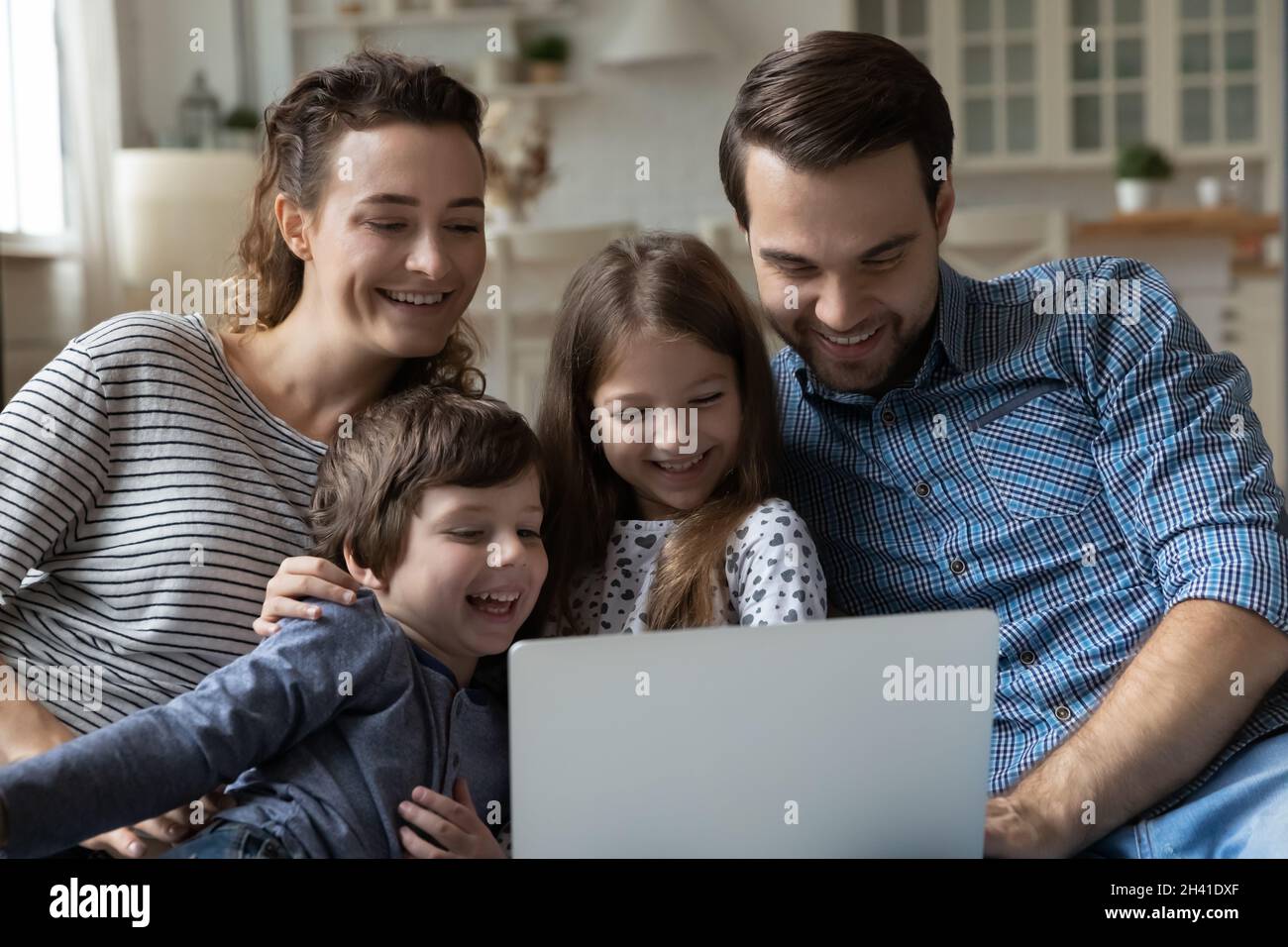 Happy young parents and little children using computer at home Stock ...