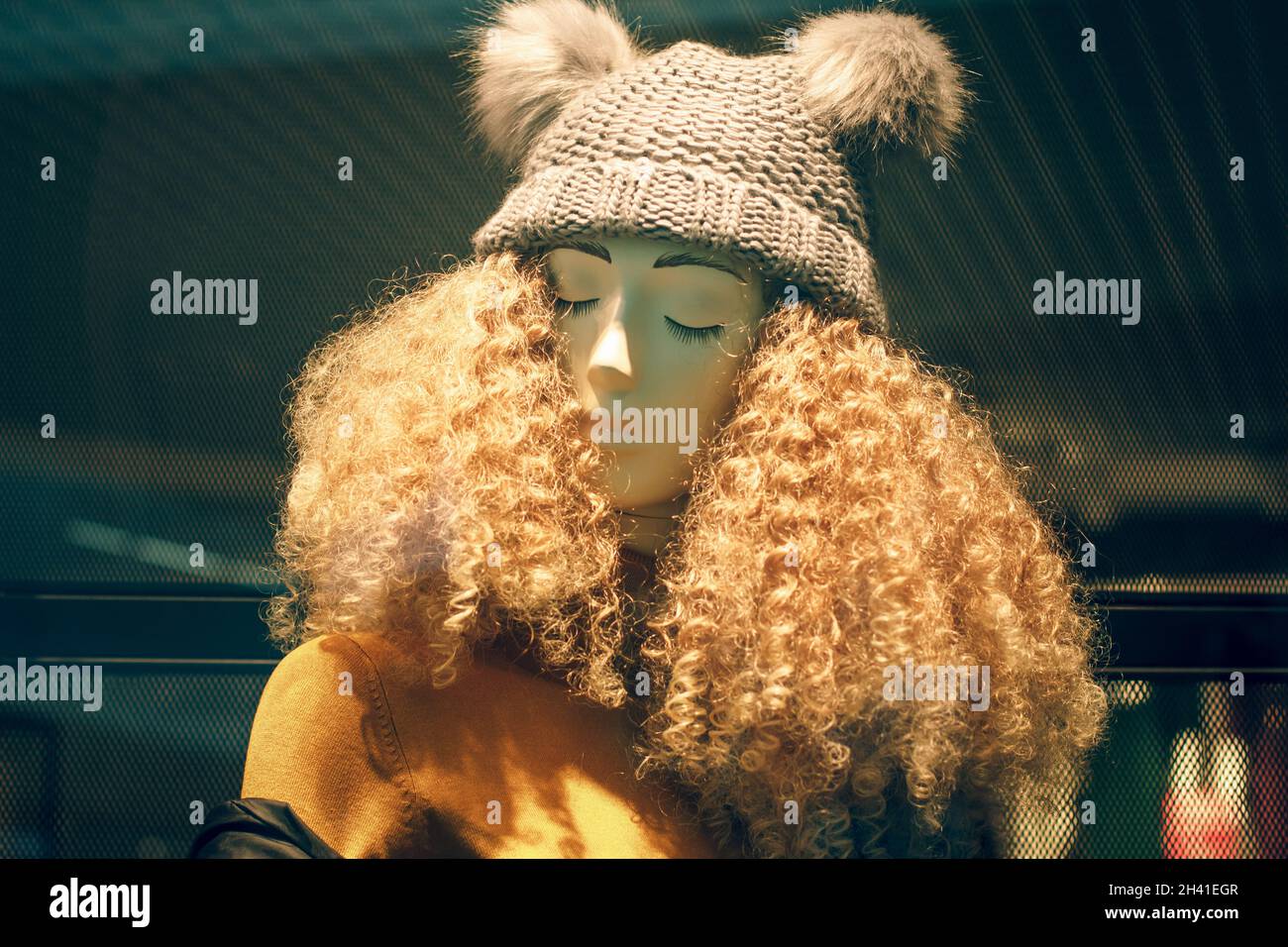 POLAND, BYDGOSZCZ - 15 february 2020: Funny mannequin in shop window. Female dummy with unruly curly hair and hat. Women's shopping. Beauty industry Stock Photo