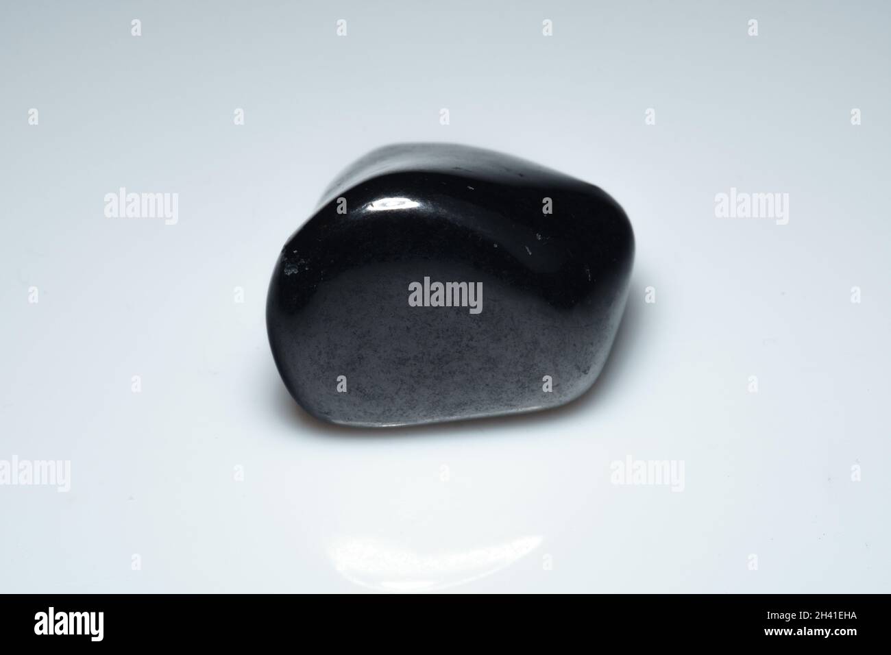 natural black shungite cabochon on background Stock Photo
