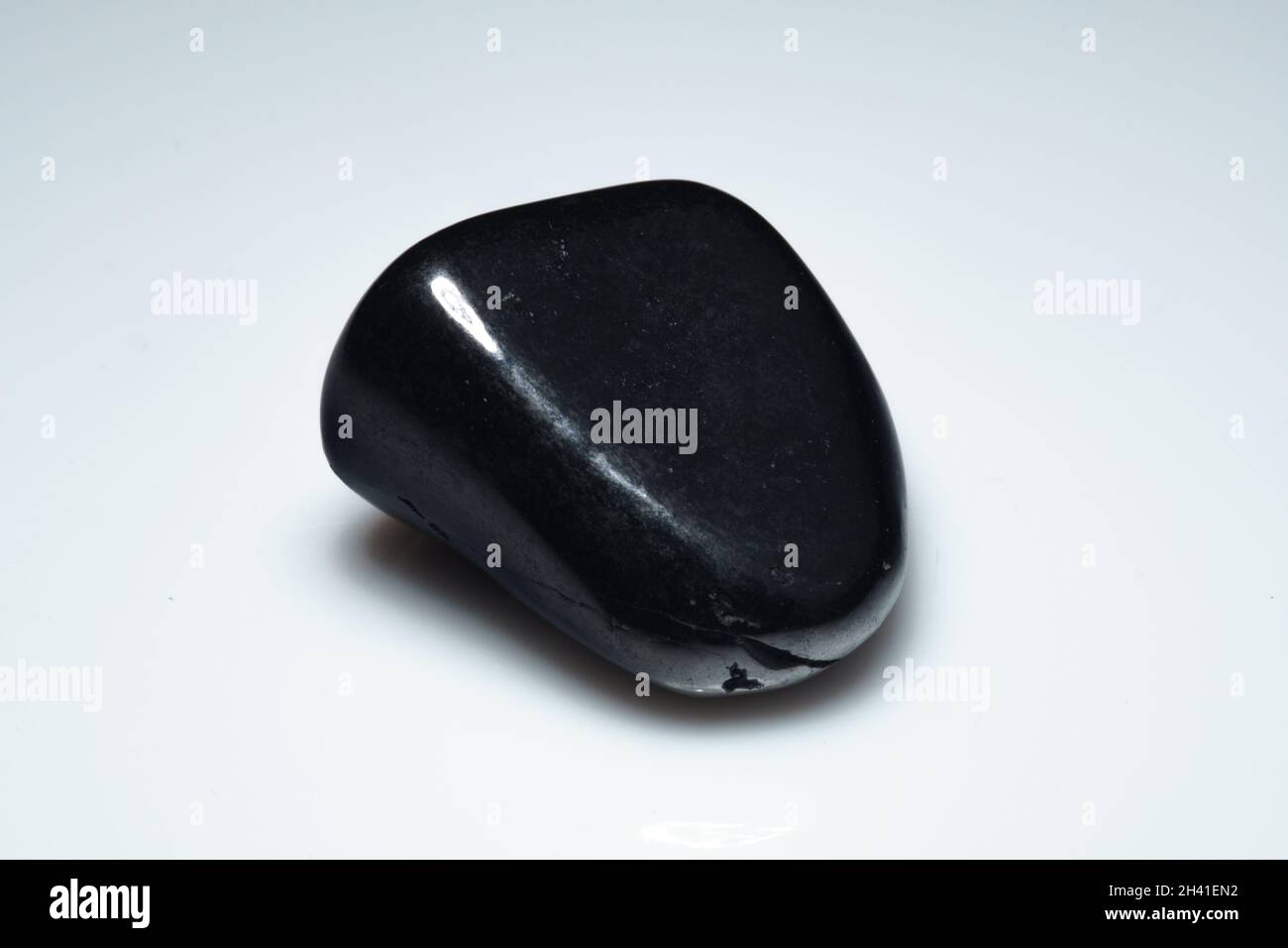 natural black shungite cabochon on background Stock Photo