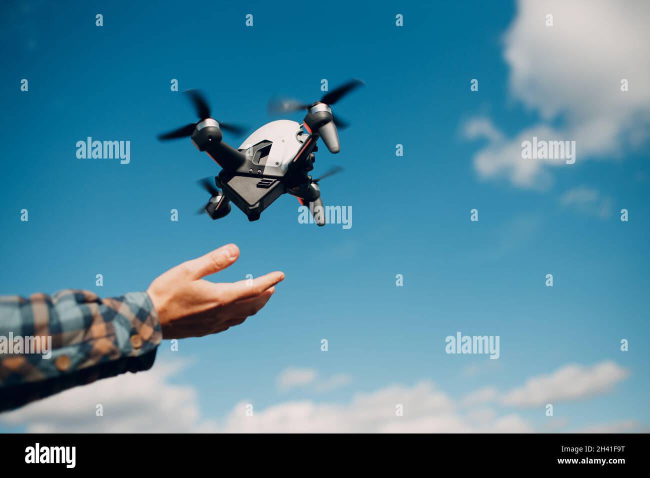 Man pilot controlling quadcopter drone with remote controller pad Stock Photo