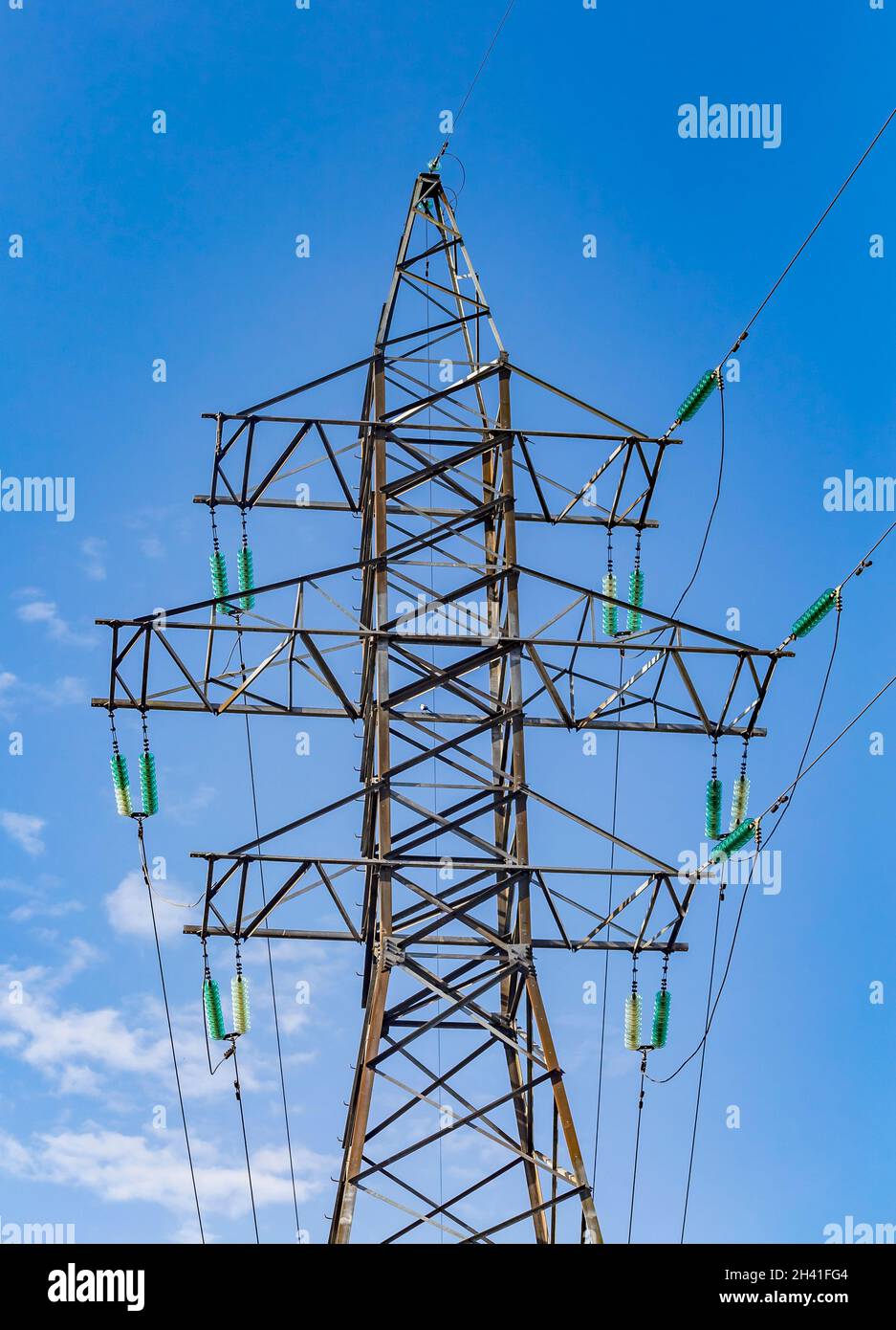 Electric tower with transparent turquoise high voltage insulators or ...