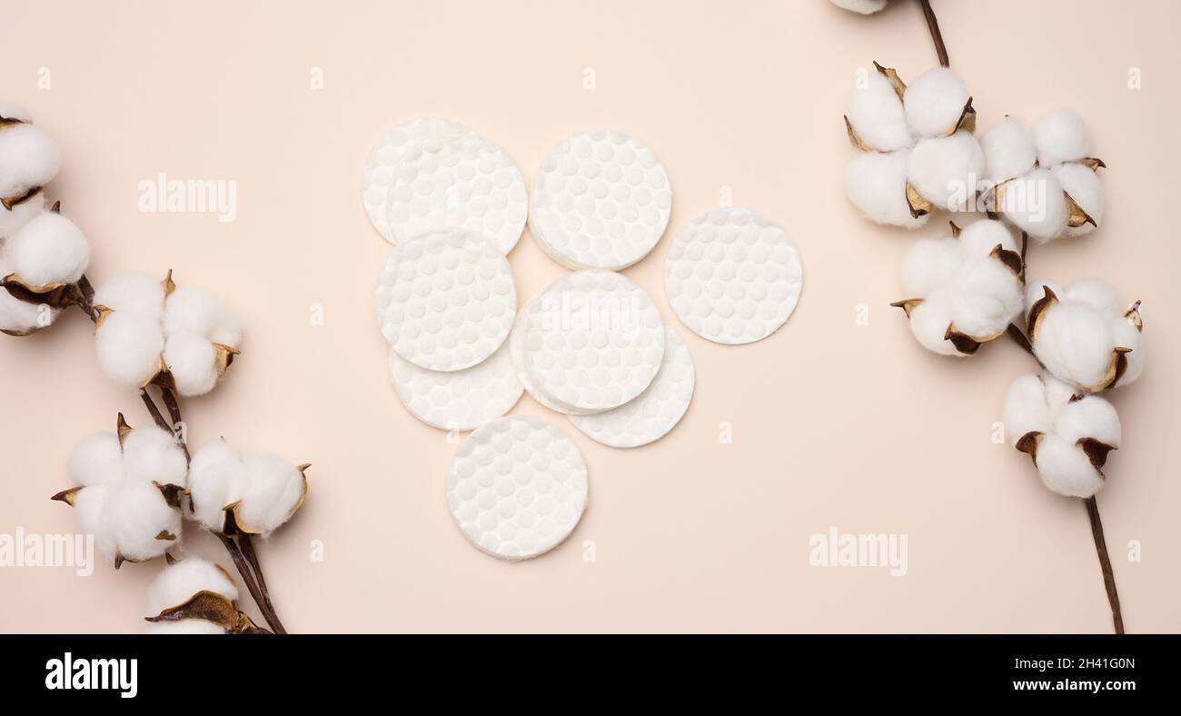 White cotton sponges on beige background. Design for the beauty, medicine and cosmetics industry Stock Photo