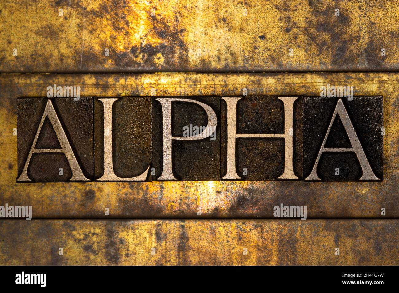 Alpha text message on textured grunge copper and vintage gold background Stock Photo