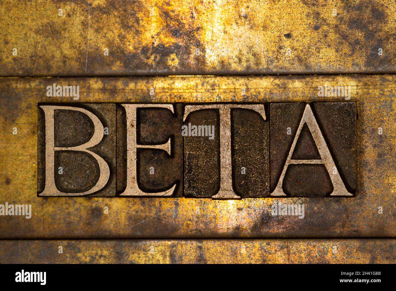 Beta text message on textured grunge copper and vintage gold background Stock Photo