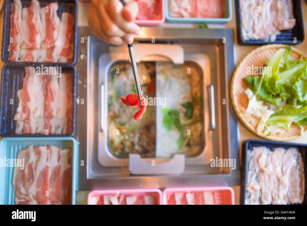 hot pot meal. Hands taking food with chopsticks. Stock Photo