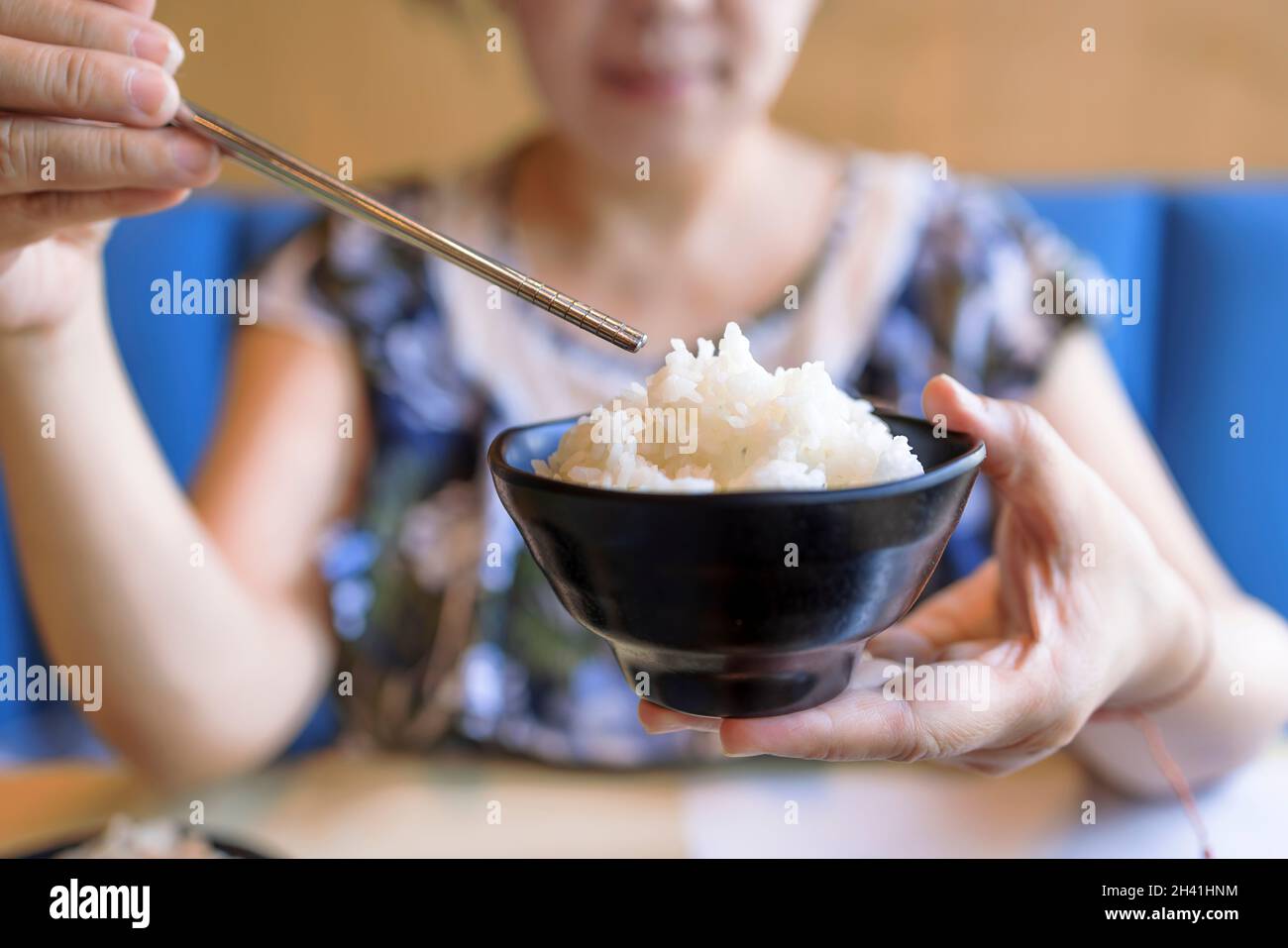Woman hands holding Bowl of tasty cooked white rice Stock Photo