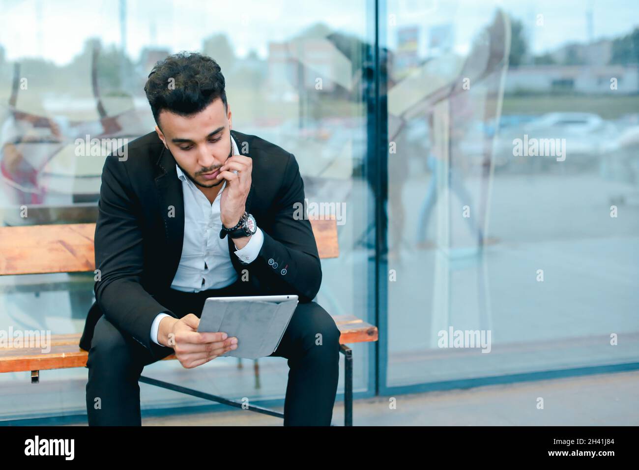 Man in suit arabic puts on sunglasses with tablet near business center Stock Photo
