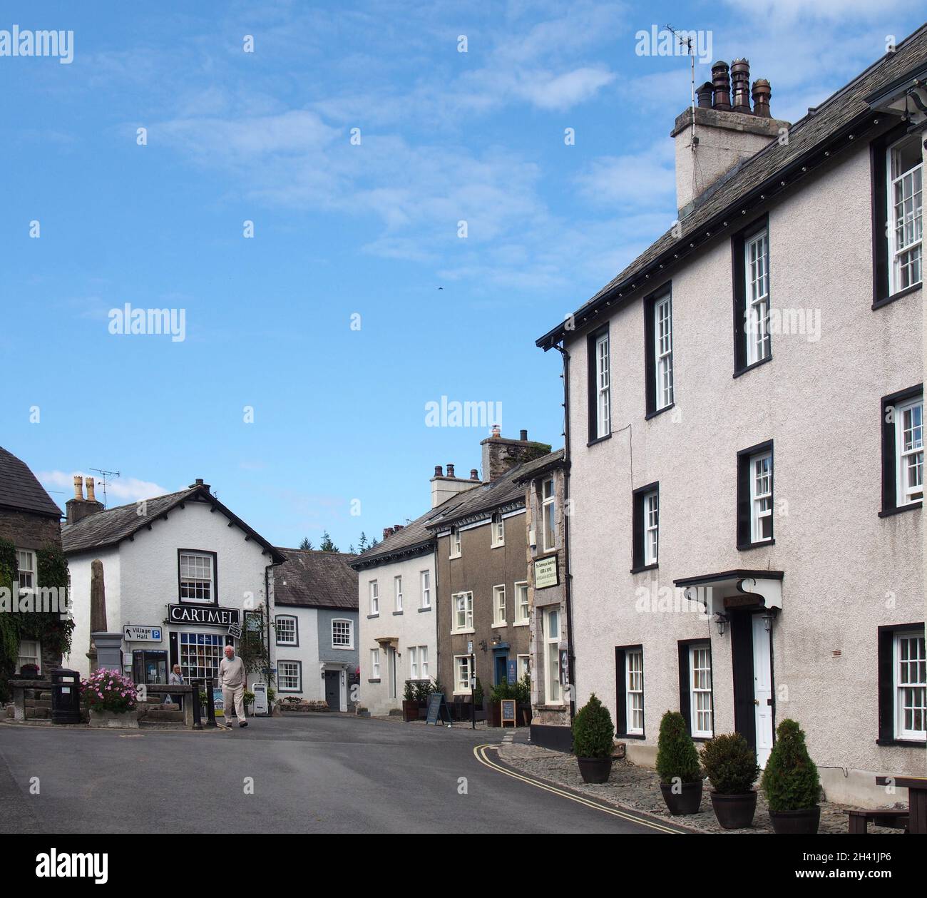 People walking in the street near the village square and shop in cartmel cumbria Stock Photo