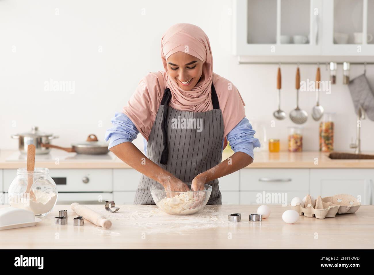 Beautiful Muslim lady In Hijab Kneading Dough While Baking In Kitchen ...