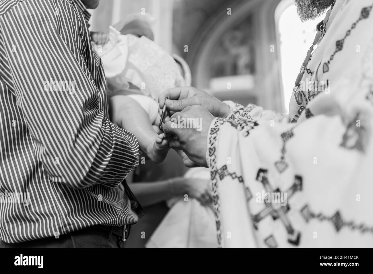 sacrament of baptism the priest baptizes the child with anointing Stock Photo