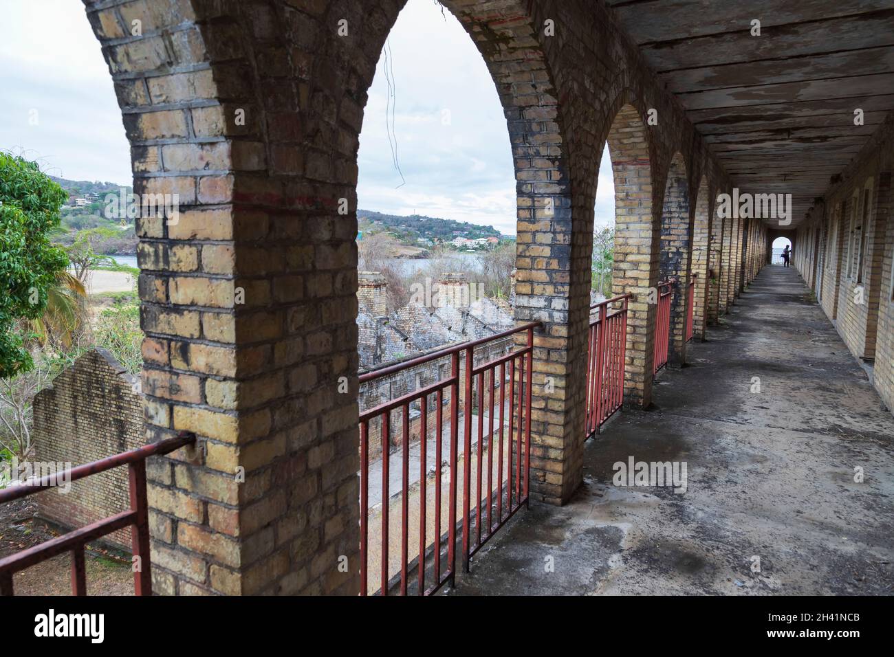 long corridor surrounded by arches and railings on the left Stock Photo