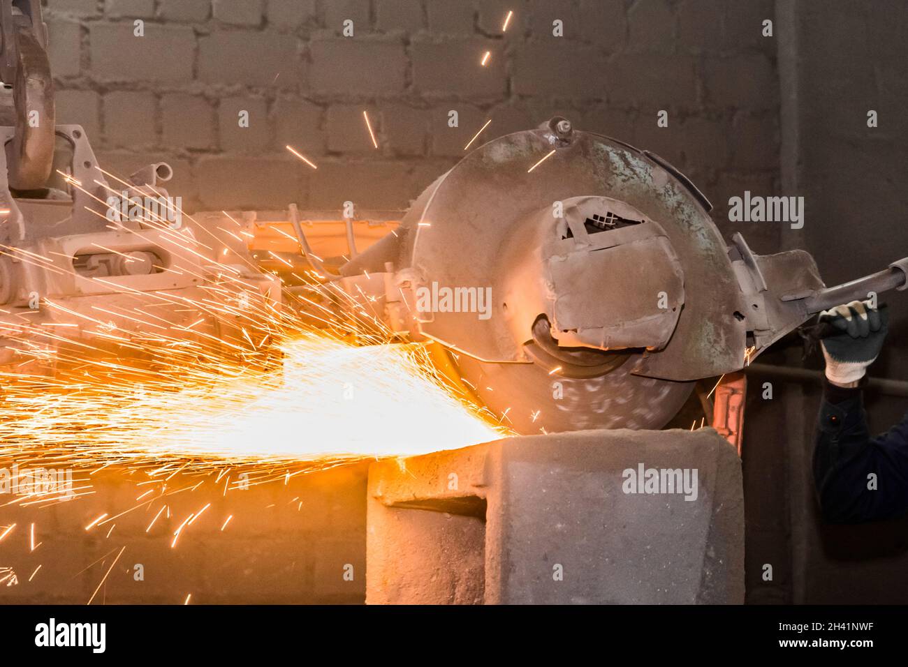 Heavy grinding equipment suspended on a chain with a hook processes and