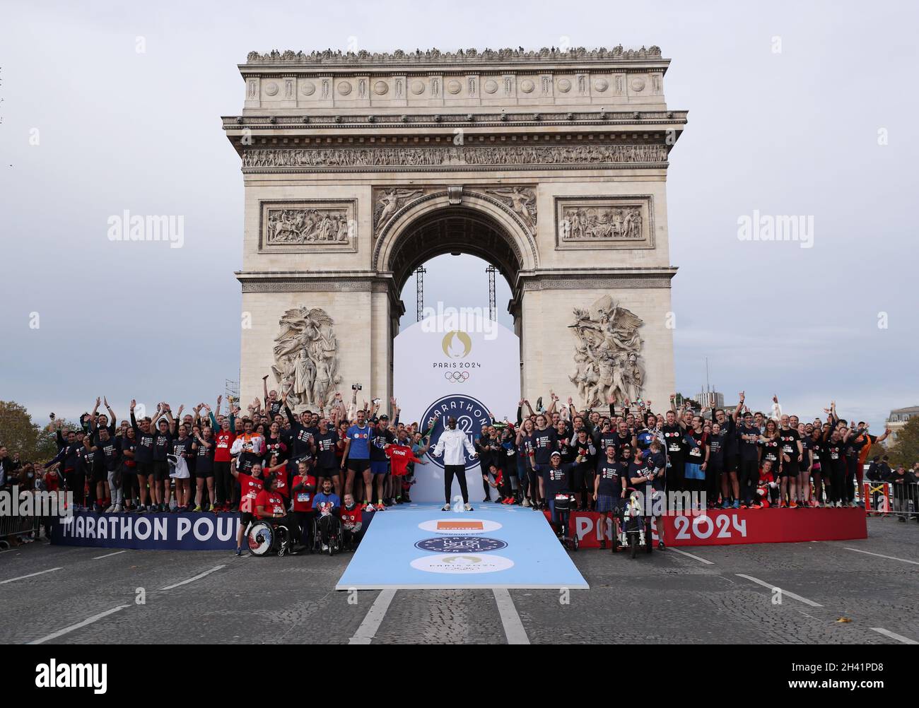 Paris, France. 31st Oct, 2021. Kenya's Eliud Kipchoge (C) poses with participants after the J-1000 Paris 2024 Marathon Pour Tous or Marathon For All, a 5km run along the Champs-Elysees marking the 1000 days countdown to the opening of Paris 2024 Olympic Games, in Paris, France, Oct. 31, 2021. Credit: Gao Jing/Xinhua/Alamy Live News Stock Photo
