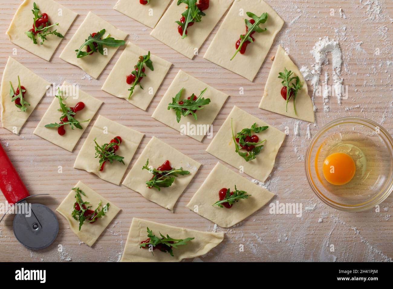 Cooking process - dough with tomato sauce and rucola - top view Stock Photo