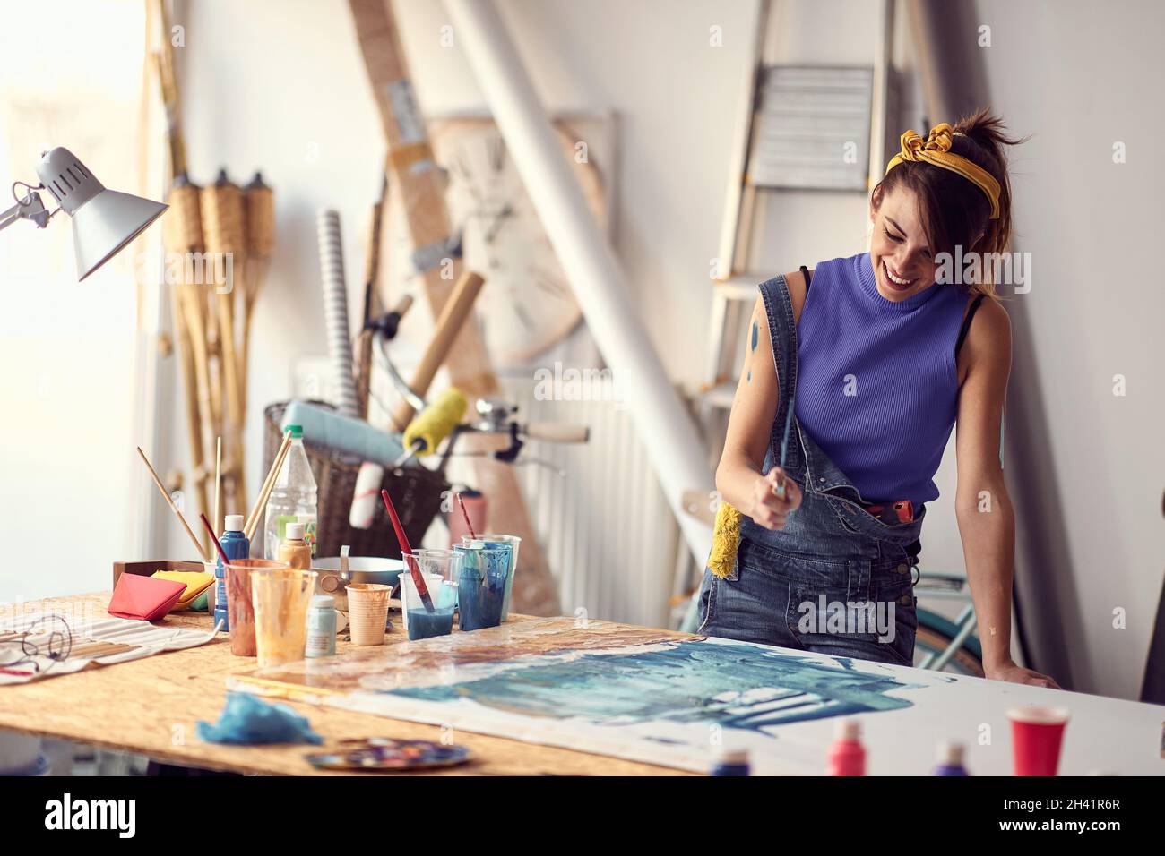 Woman painter drawing on a canvas in art studio. Stock Photo