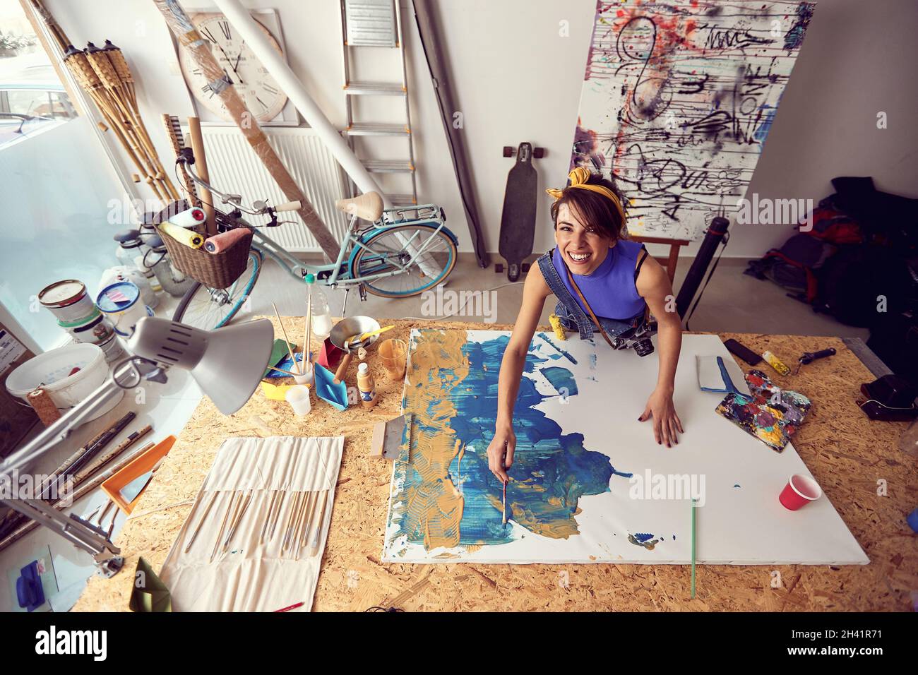 Woman painter at workspace.Smiling artist working on new paint Stock Photo
