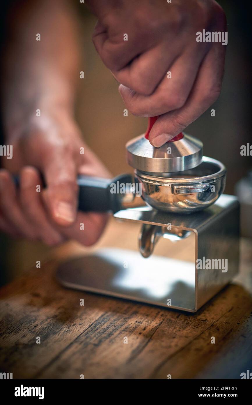 Close-up view of a barman's hands preparing an aromatic and fragrant espresso. Coffee, beverage, bar Stock Photo