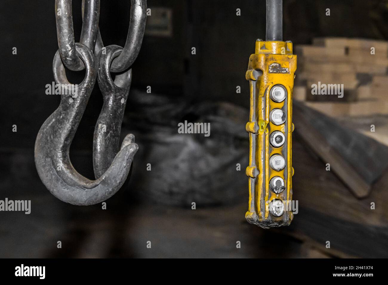 Remote control old control panel lifting industrial mechanism iron hook in the workshop of the industrial plant. Stock Photo