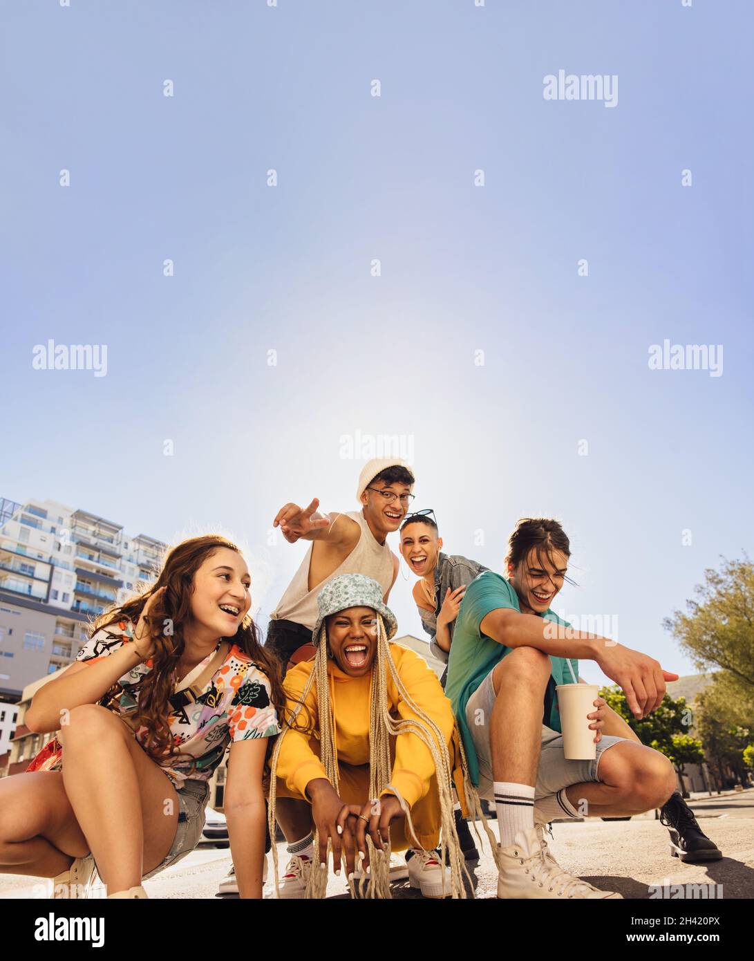Diverse group of friends having fun in the city. Group of multiethnic generation z friends enjoying spending time together. Cheerful young friends mak Stock Photo