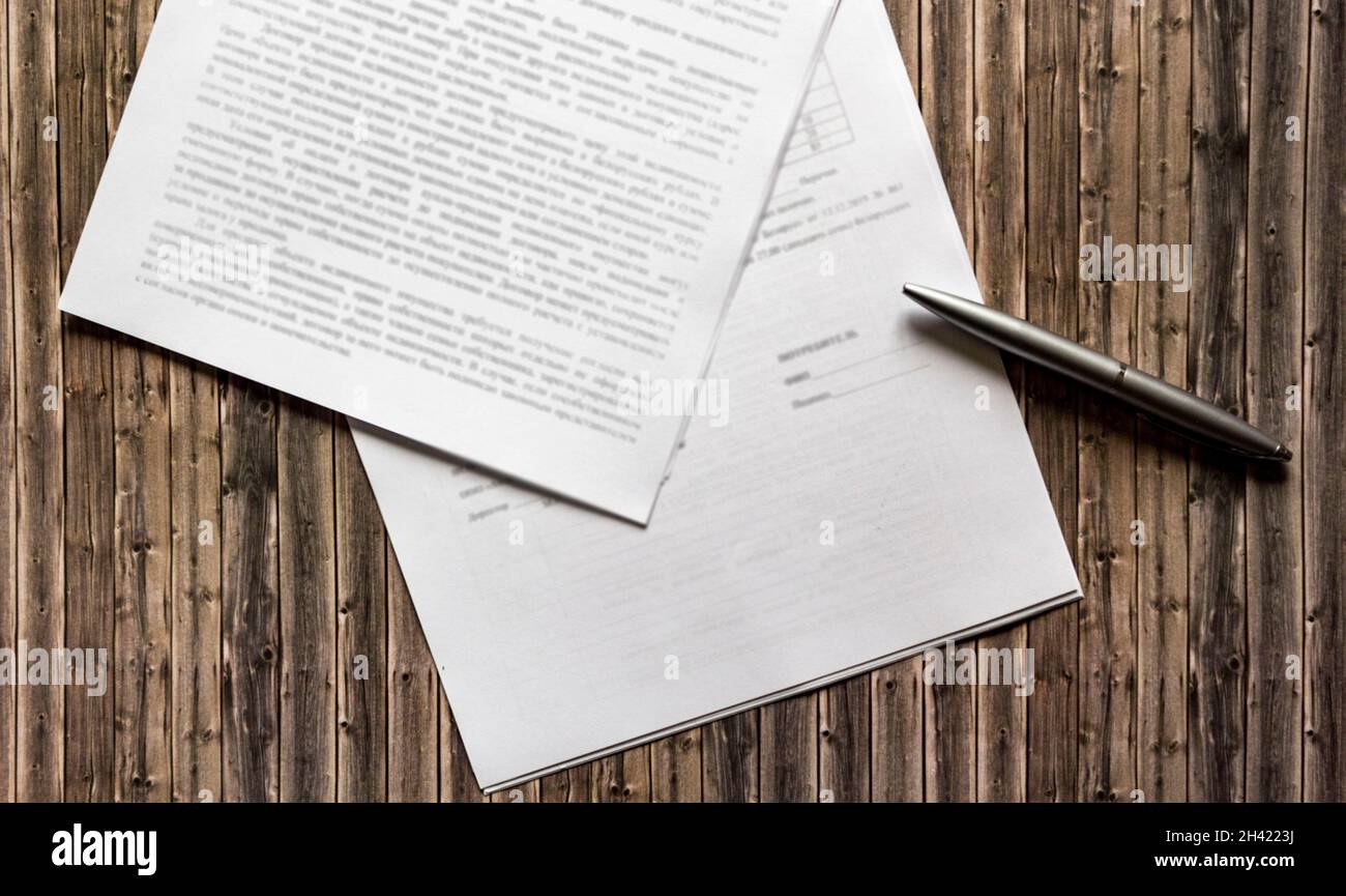 Pen and contract papers on wooden desk Stock Photo