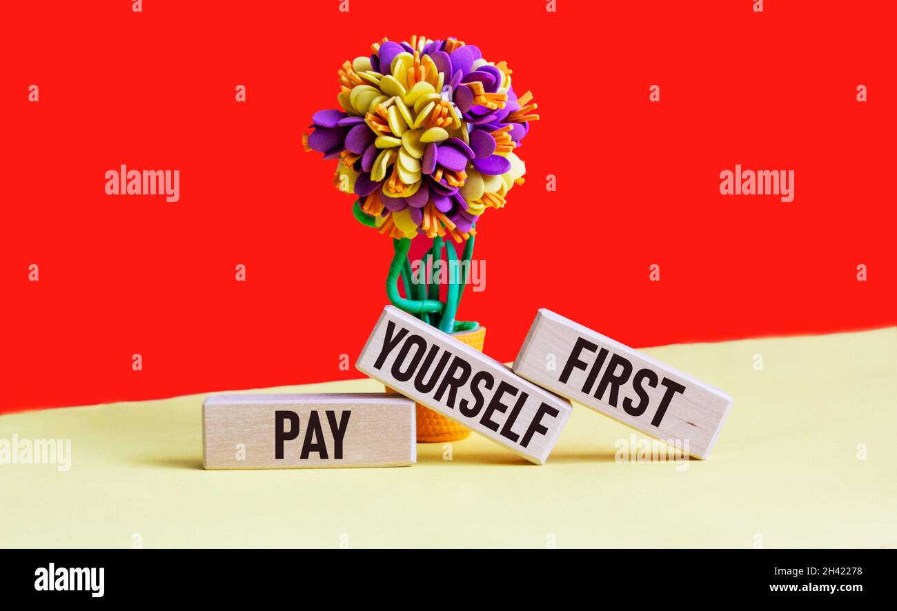 On the wooden blocks it says, Pay Yourself First. Motivational Sign. Business photography showcasing personal finance. Save money for the future writt Stock Photo